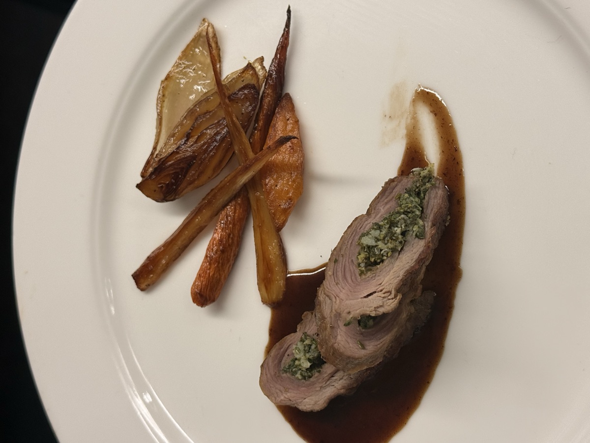 Herb-stuffed meat roulade with roasted vegetables — fine dining presentation