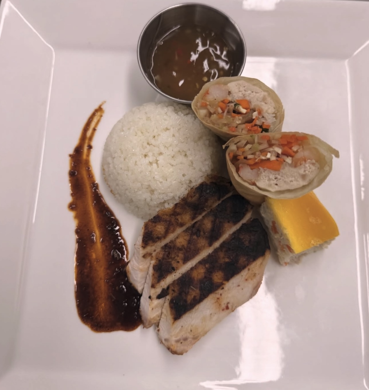 Grilled chicken plate with jasmine rice and spring rolls — catering spread